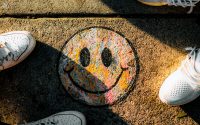 Smiley Face drawn on sidewalk with shoes in frame